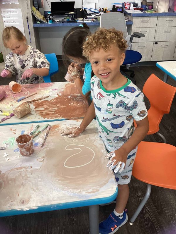 LEAP Early Childhood Center boy painting at an activity table