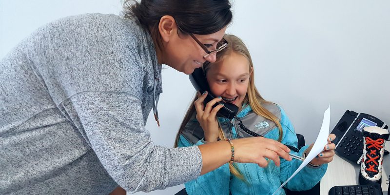 female staff member coaching a female student while she is speaking on the phone